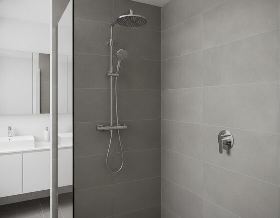 Fixed shower head on a wall arm producing an even overhead spray